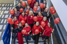 Pracownicy Politechniki Rzeszowskiej w czerwonych strojach, z czerwonymi balonami, 